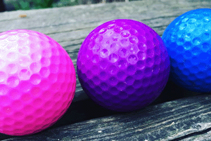 Golf balls, in pink, purple, and blue